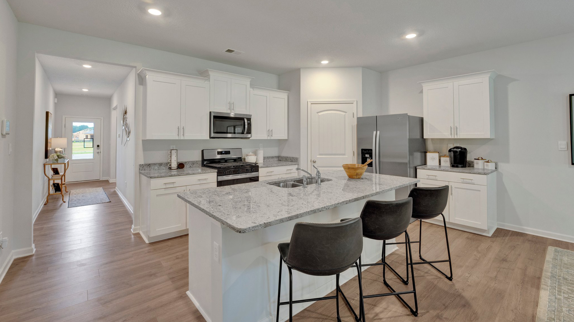 cameron plan kitchen with bar seating at the island, granite counterops, walk-in corner pantry, and stainless steel appliances included in the orchard community
