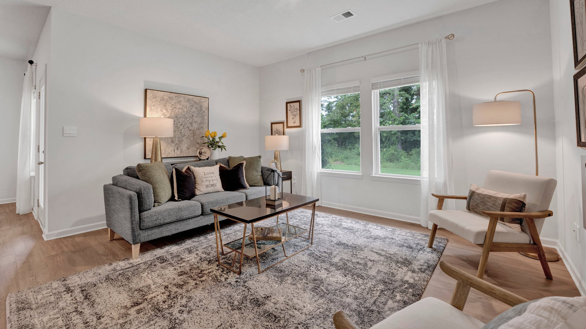 cameron plan living room with large double window overlooking the back yard allowing lots of natural light in in the orchard community