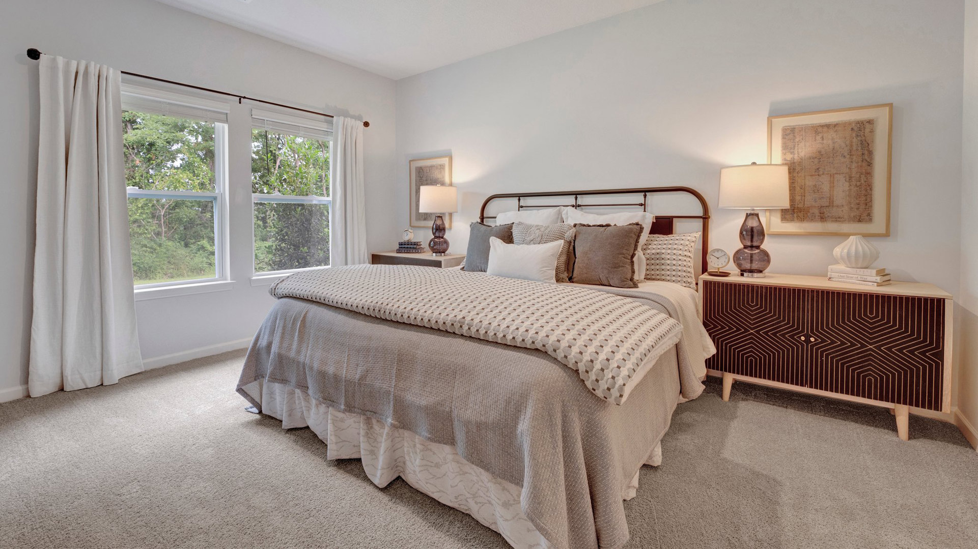 cameron plan primary bedroom with carpet flooring, large double-window overlooking the backyard, and king size bed with additional furniture fitting comfortably in the orchard community