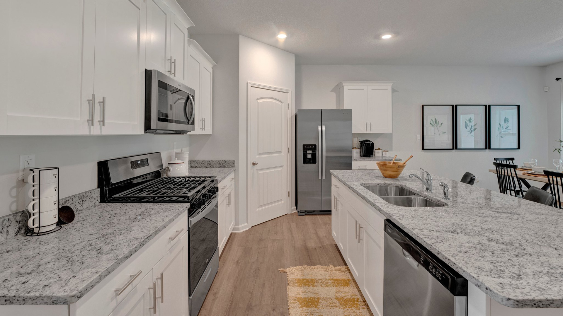 cameron plan kitchen with granite countertops, walk-in corner pantry, and stainless steel appliances included in the orchard community