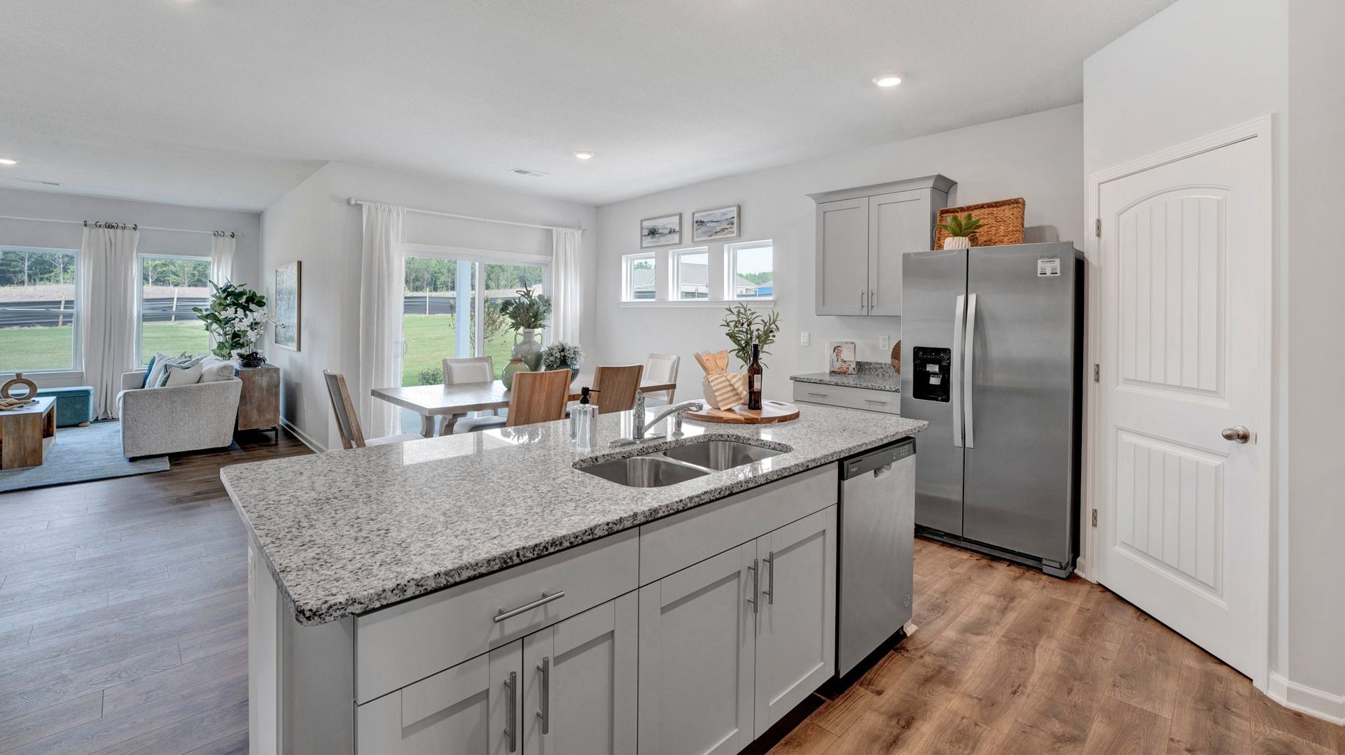 dover plan kitchen island with granite countertops overlooking the dining area in the orchard community