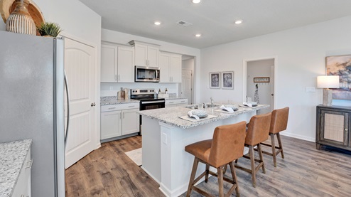 Beautiful kitchen area with light cabinets and stainless steel appliances
