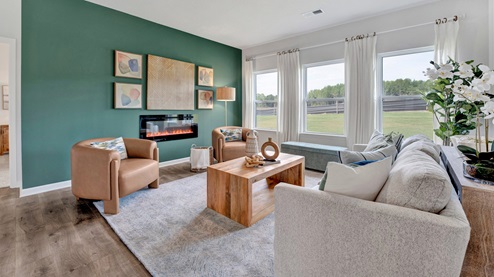 living room with natural light from 3 large windows, an electric fireplace, and ample room for large furniture