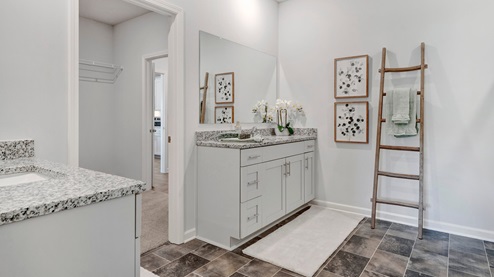 primary bathroom with separate vanities that include their own sink and granite countertops