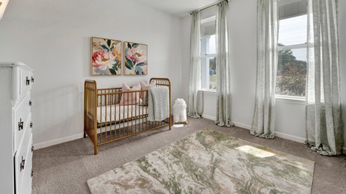 secondary bedroom at the front of the home with 2 tall windows overlooking the front porch