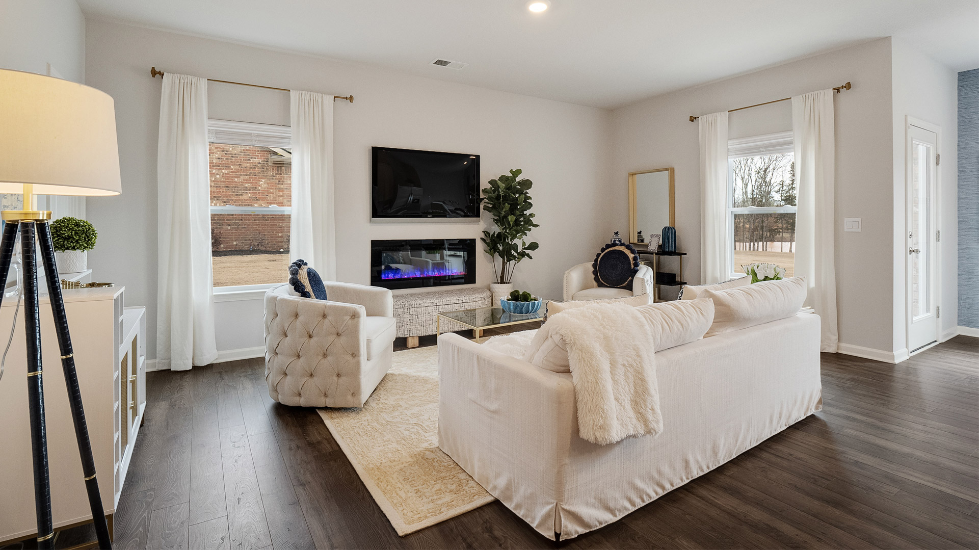 lacombe floorplan in indian oaks community living room with electric fireplace and revwood laminate flooring