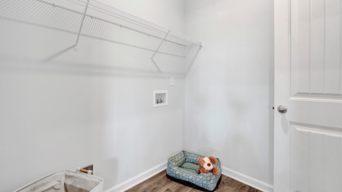 laundry room with ventilated shelving and laminate flooring