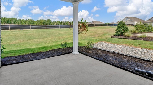 covered patio overlooking backyard that comes fully sodded