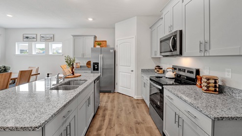 kitchen with gray cabinets, granite countertops and stainless steel appliances