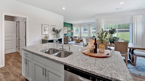 kitchen overlooking open floorplan living including dining room and living room