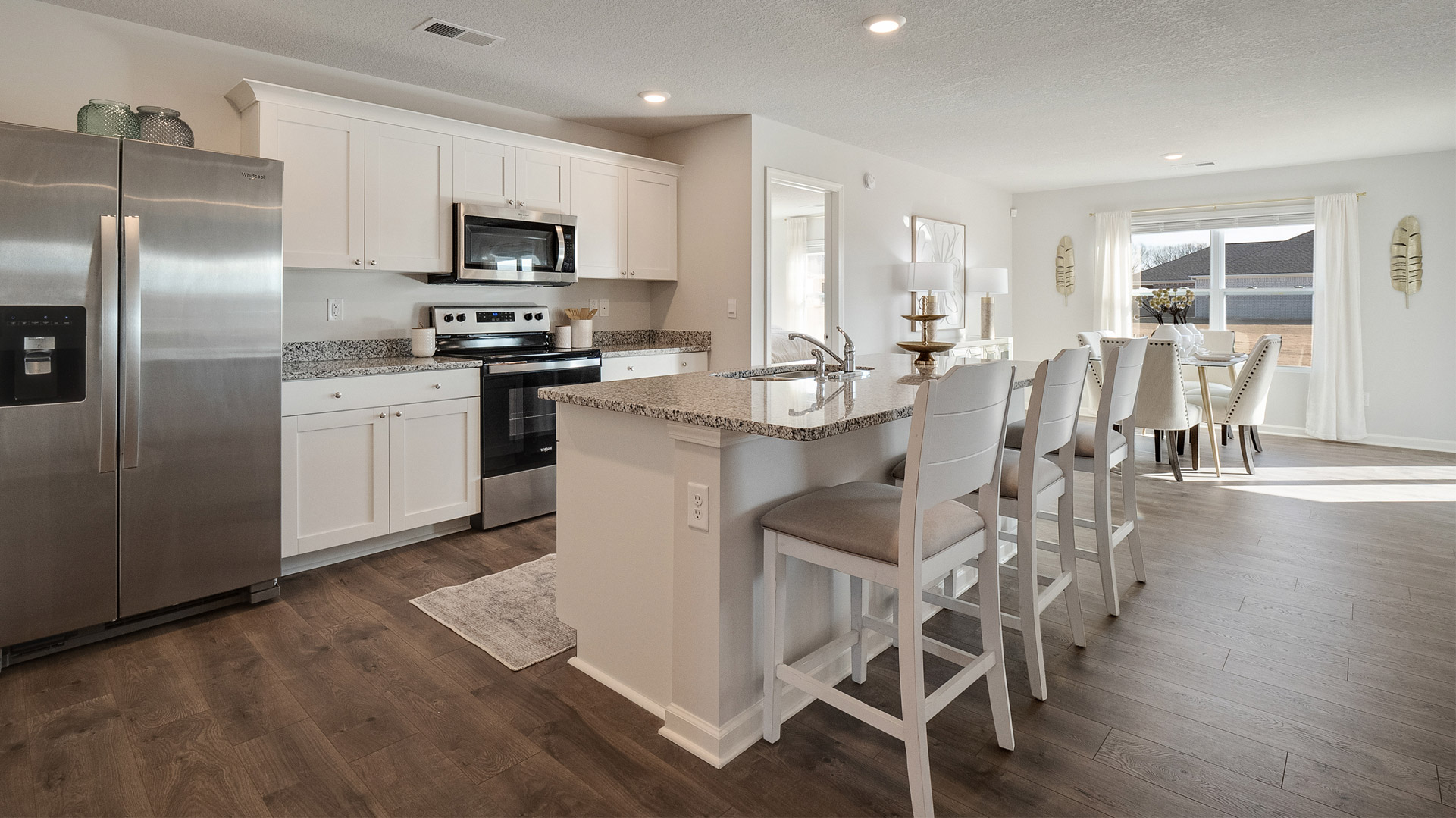Beautiful kitchen area with light cabinets and stainless steel appliances