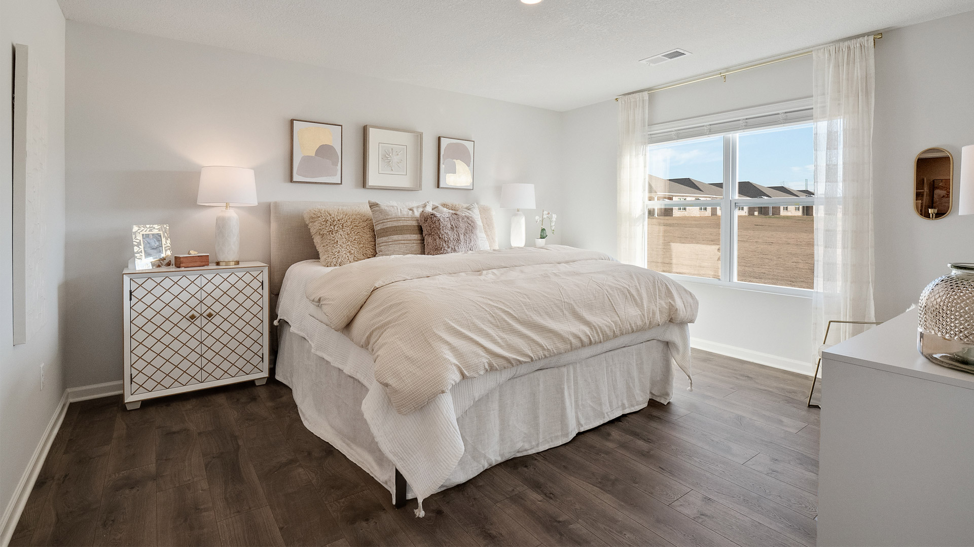 Primary bedroom with a large double window overlooking the backyard
