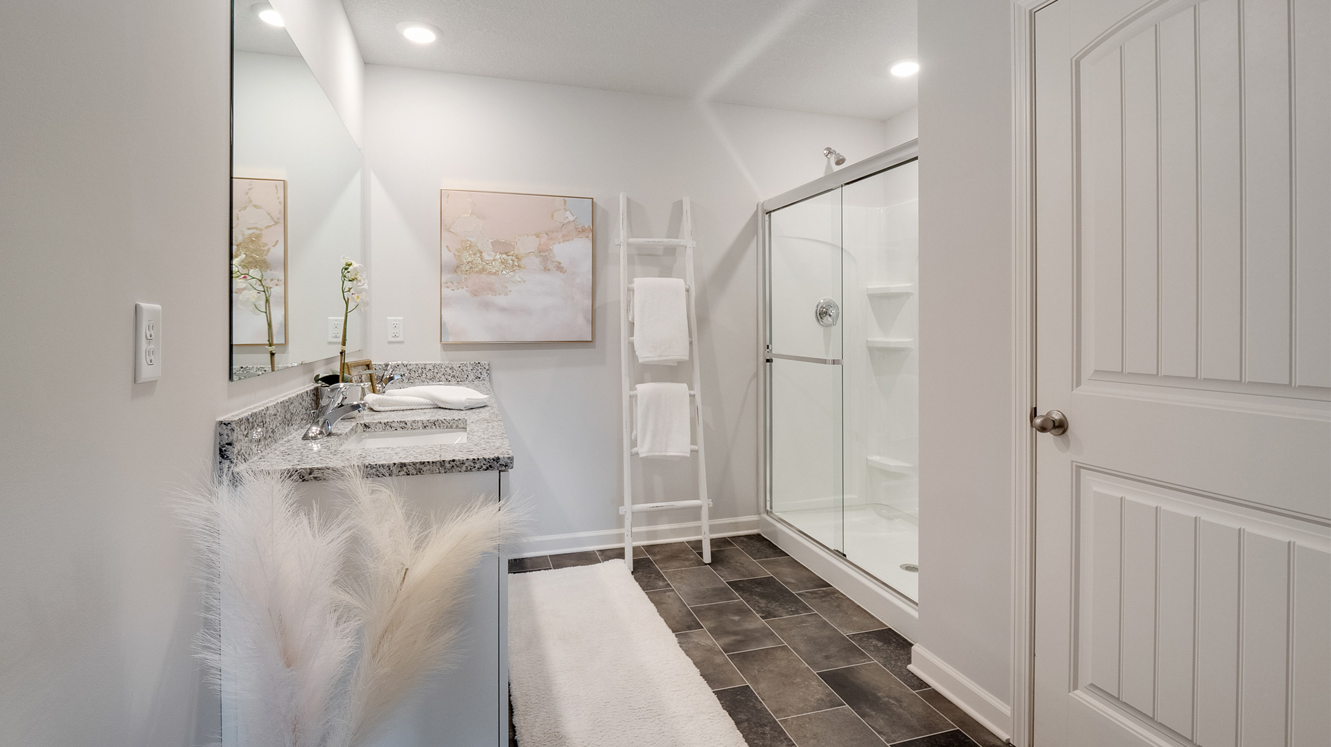 EN suite primary bathroom with a dual vanity and a walk in shower
