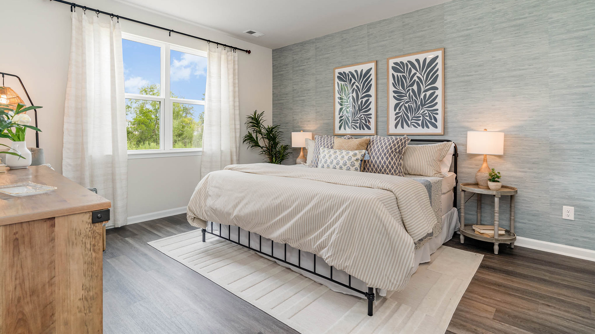 bedroom with a black bed and a large window