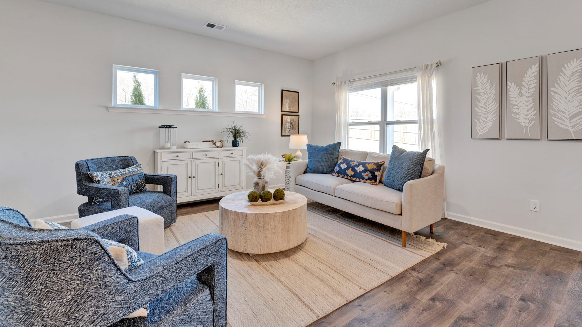 Spacious living room with a double window overlooking the back covered patio