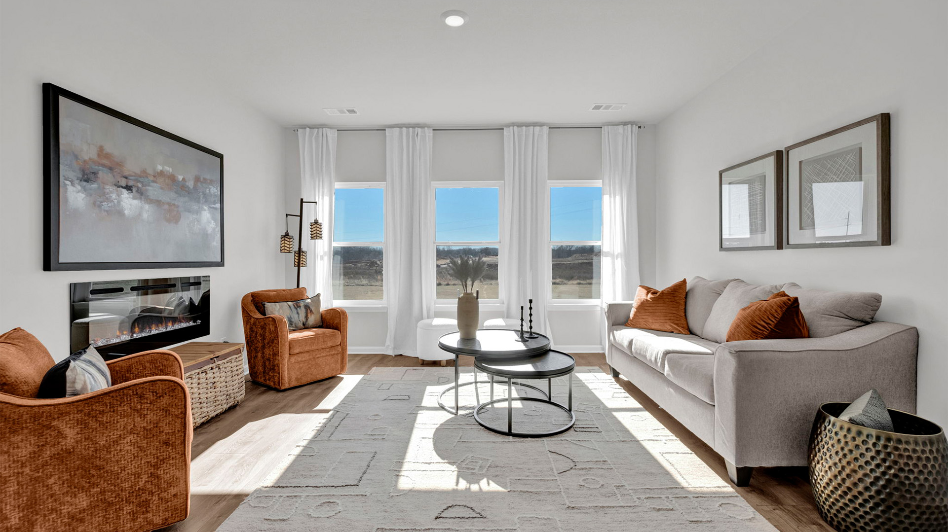 Living room with three tall window overlooking the backyard