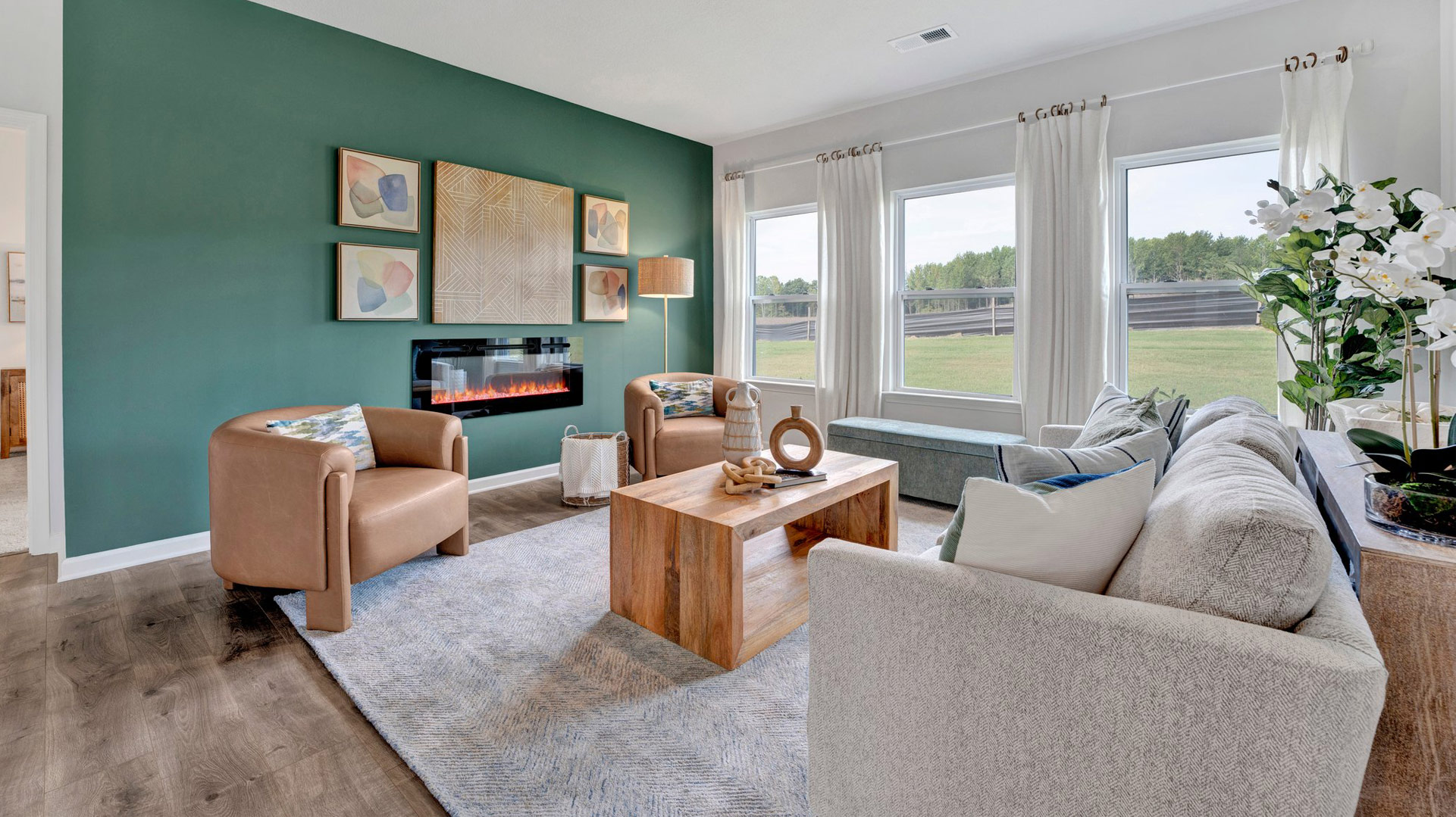 Living room with three tall window overlooking backyard