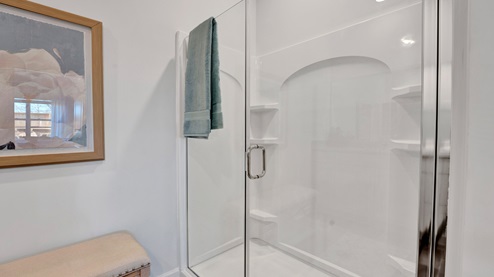 En suite primary bathroom with a glass enclosed walk in shower