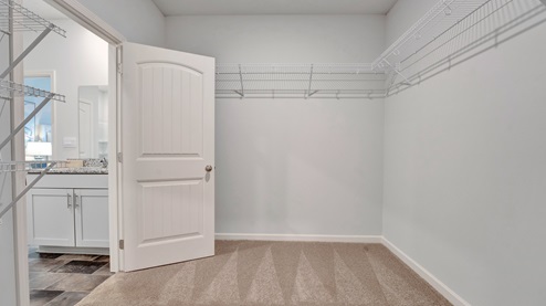 Spacious primary closet with ventilated shelving for more storage space