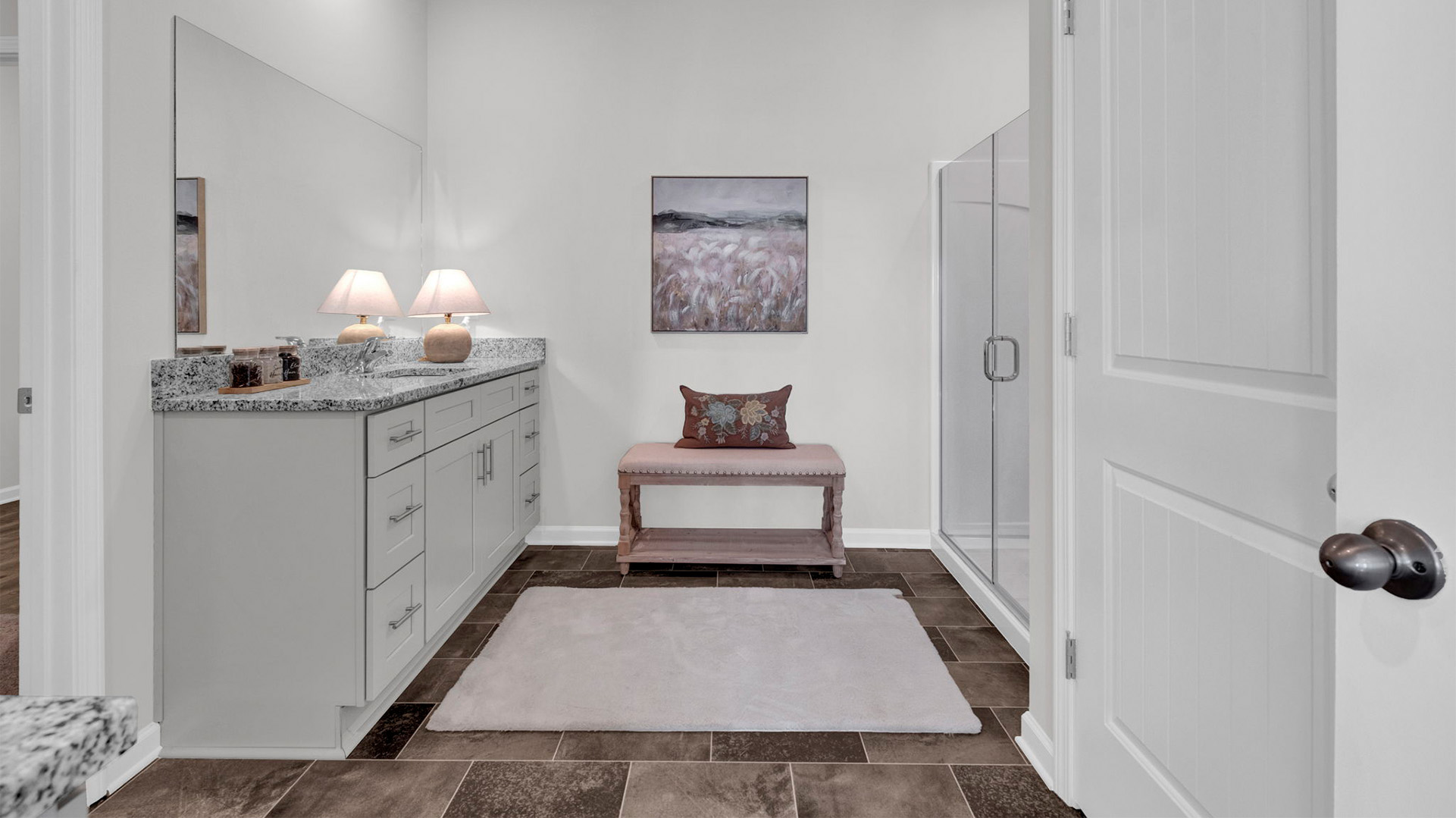 En suite bathroom with granite countertop vanities