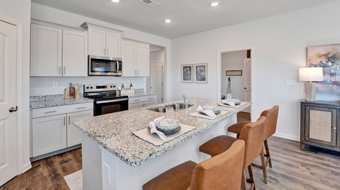 Beautiful kitchen area with light cabinets and stainless steel appliances