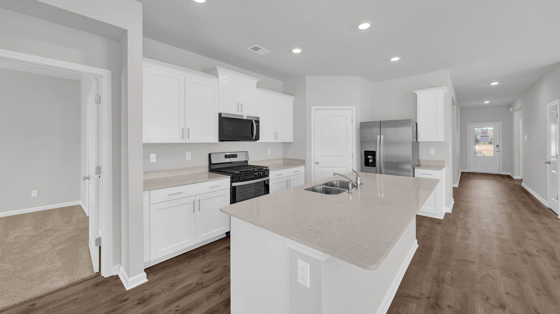 Beautiful kitchen opens up at the end of entry hall