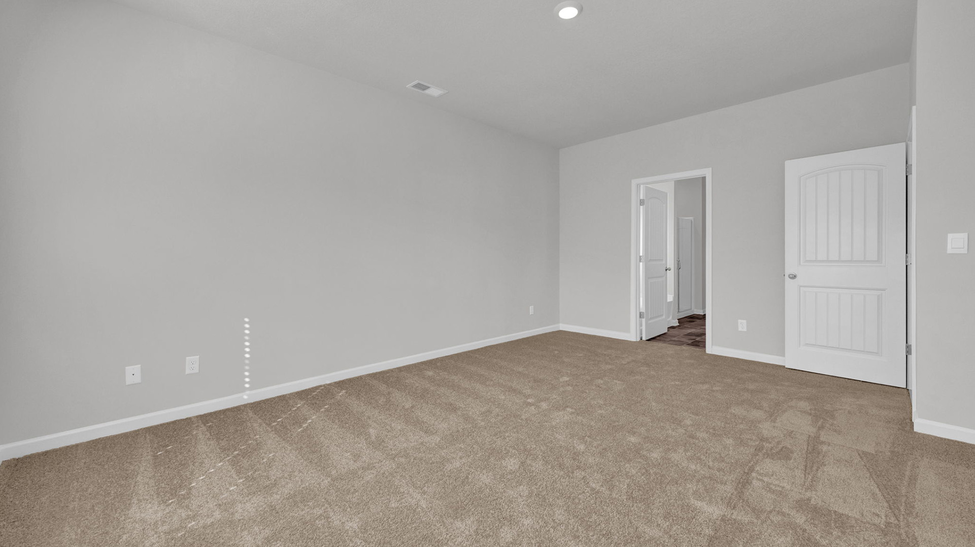 Spacious primary bedroom comfortably fitting a king size bed