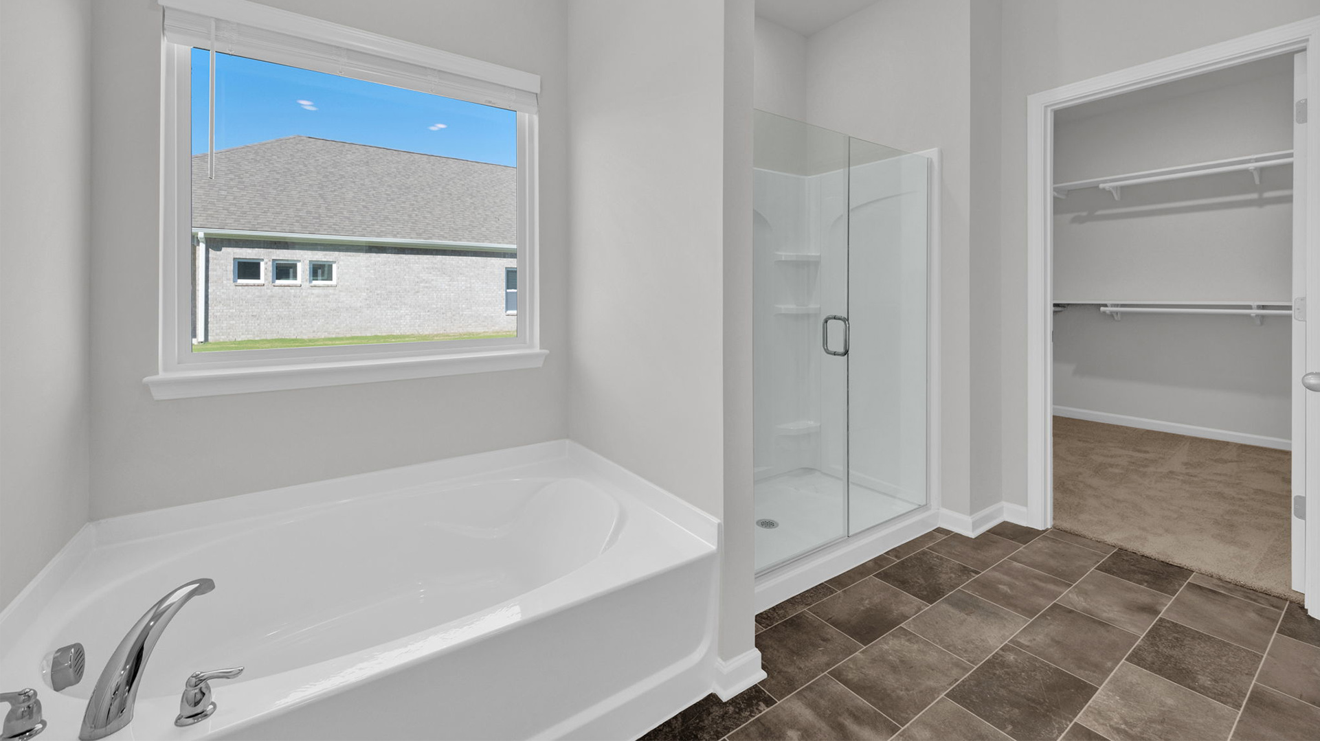 EN suite primary bathroom with a tub and a large window overlooking