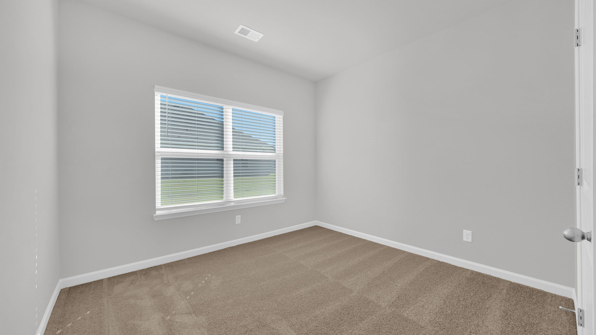 Second bedroom with a large double window for natural light