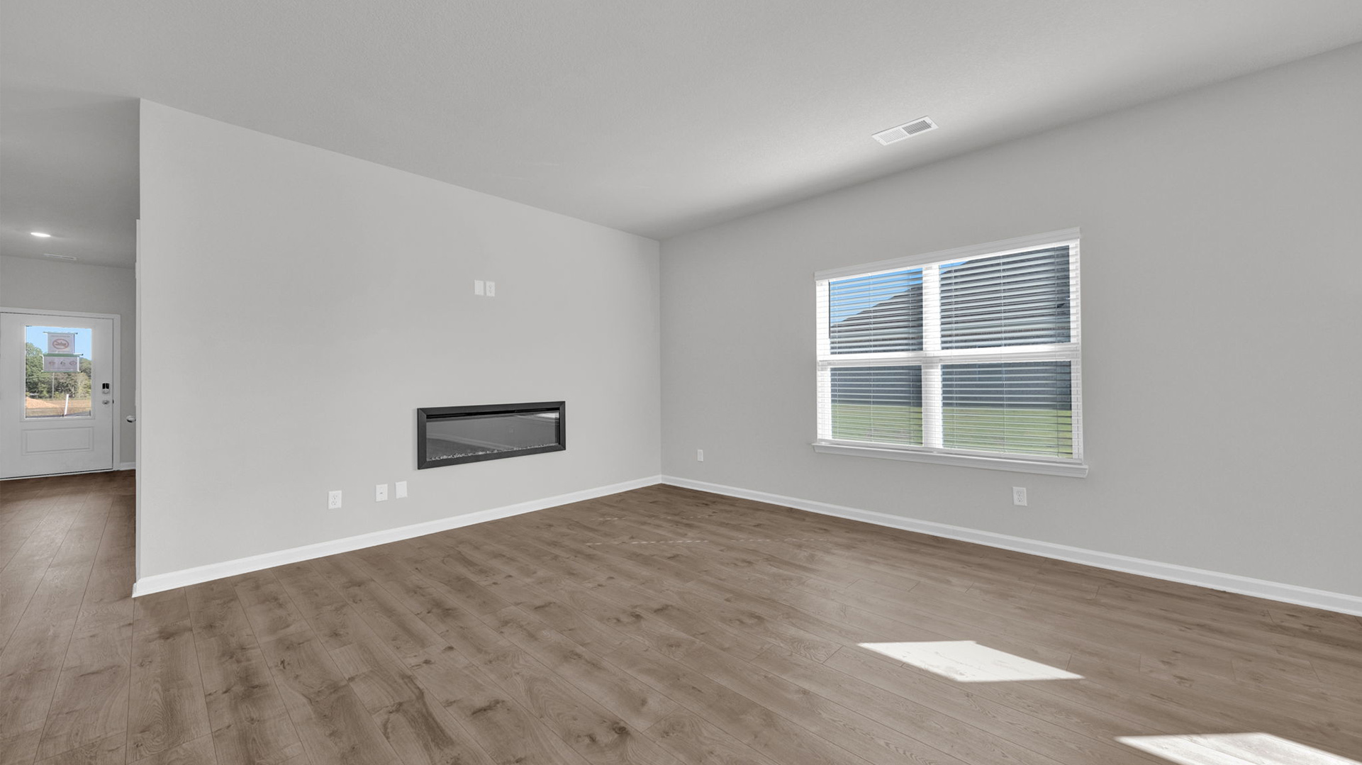 Spacious living room opens up at the end of entry hall