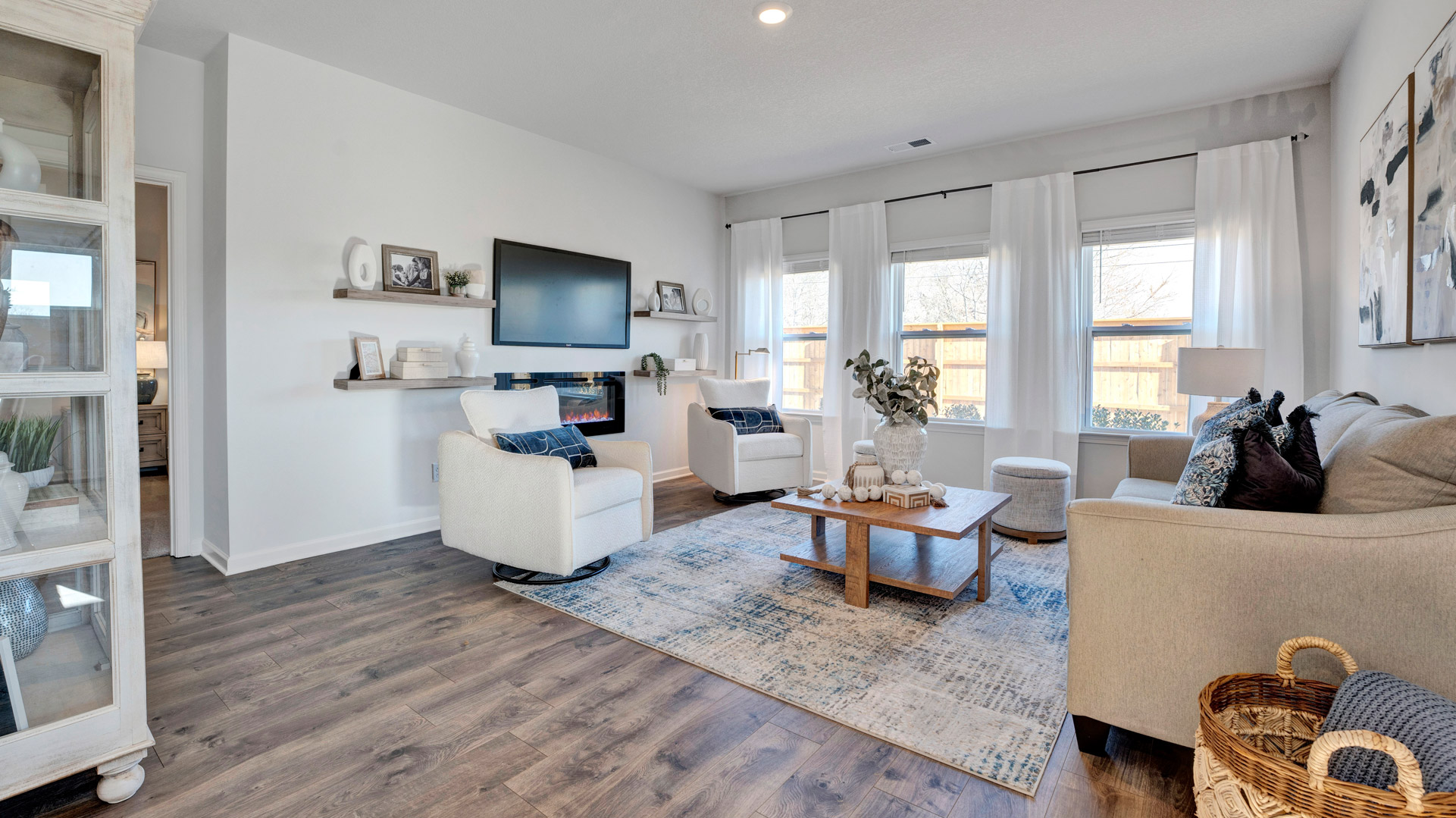 Living room looking to kitchen, dining, outdoor areas in this new home features natural light, with fresh open concept flow