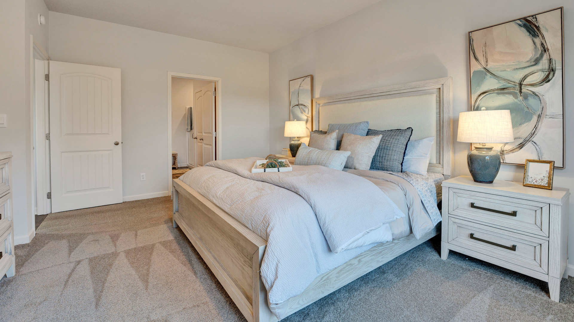 Primary bedroom features ample space, double windows, soft carpet, a stylish walk-in closet, and a private ensuite bath