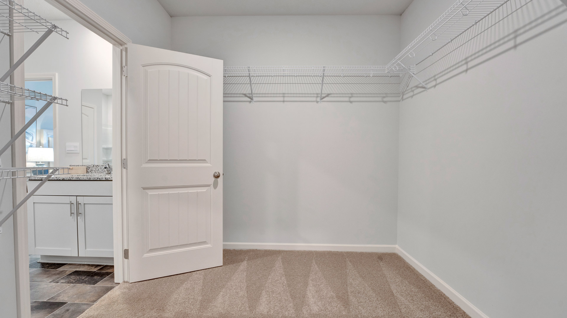 Primary suite walk-in closet in Langdon new home with built-in shelving and generous storage