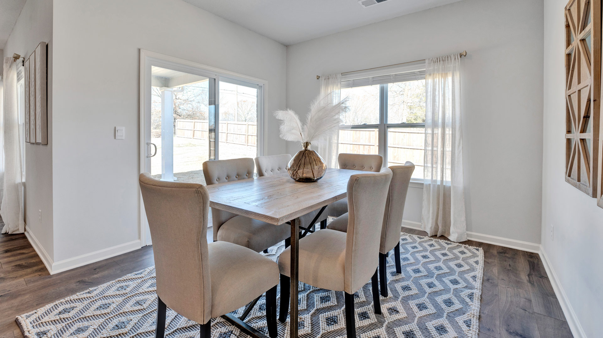 Open concept dining area with simple furnishings and a sliding door.