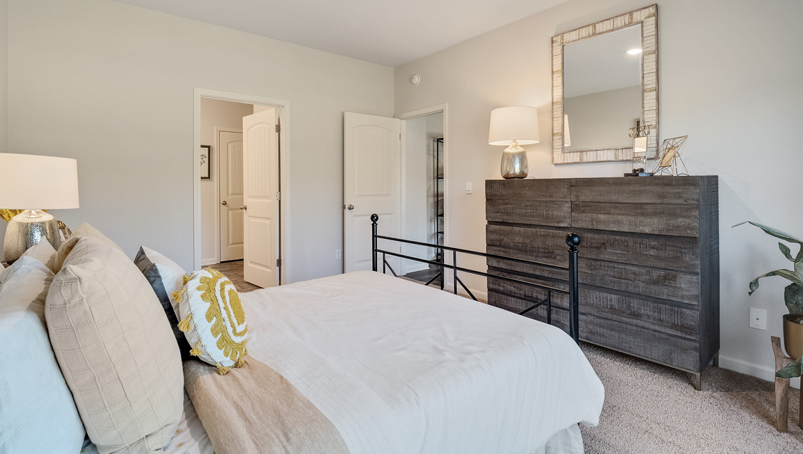 Bedroom with neutral walls, closet space, and natural lighting.