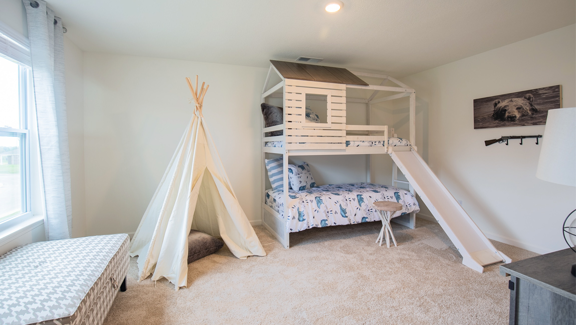 Bedroom with neutral walls, furnishings, and a window.
