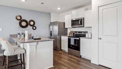 Kitchen area with light cabinets and stainless steel appliances