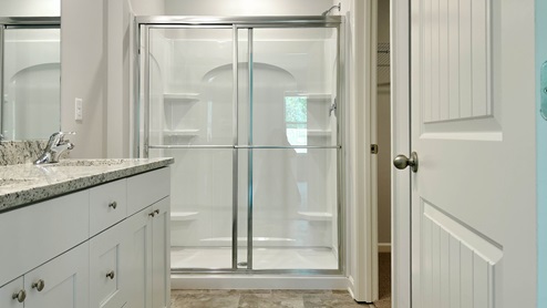 En suite primary bathroom with a glass enclosed walk in shower