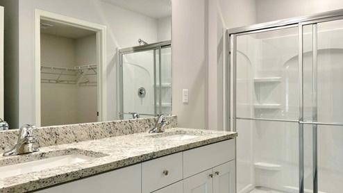 En suite primary bathroom with a single vanity and two sinks