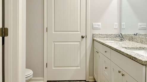 En suite primary bathroom with a granite countertop vanity