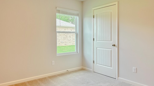 Third bedroom with a window overlooking the side yard