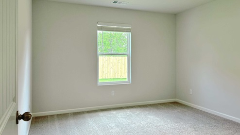 Primary bedroom with carpet flooring and neutral walls