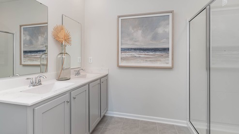 EN suite primary bathroom with a single vanity and double sinks with a glass enclosed walk in shower
