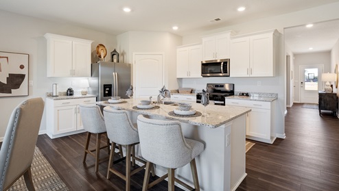 Kitchen area with light cabinets and stainless steel appliances