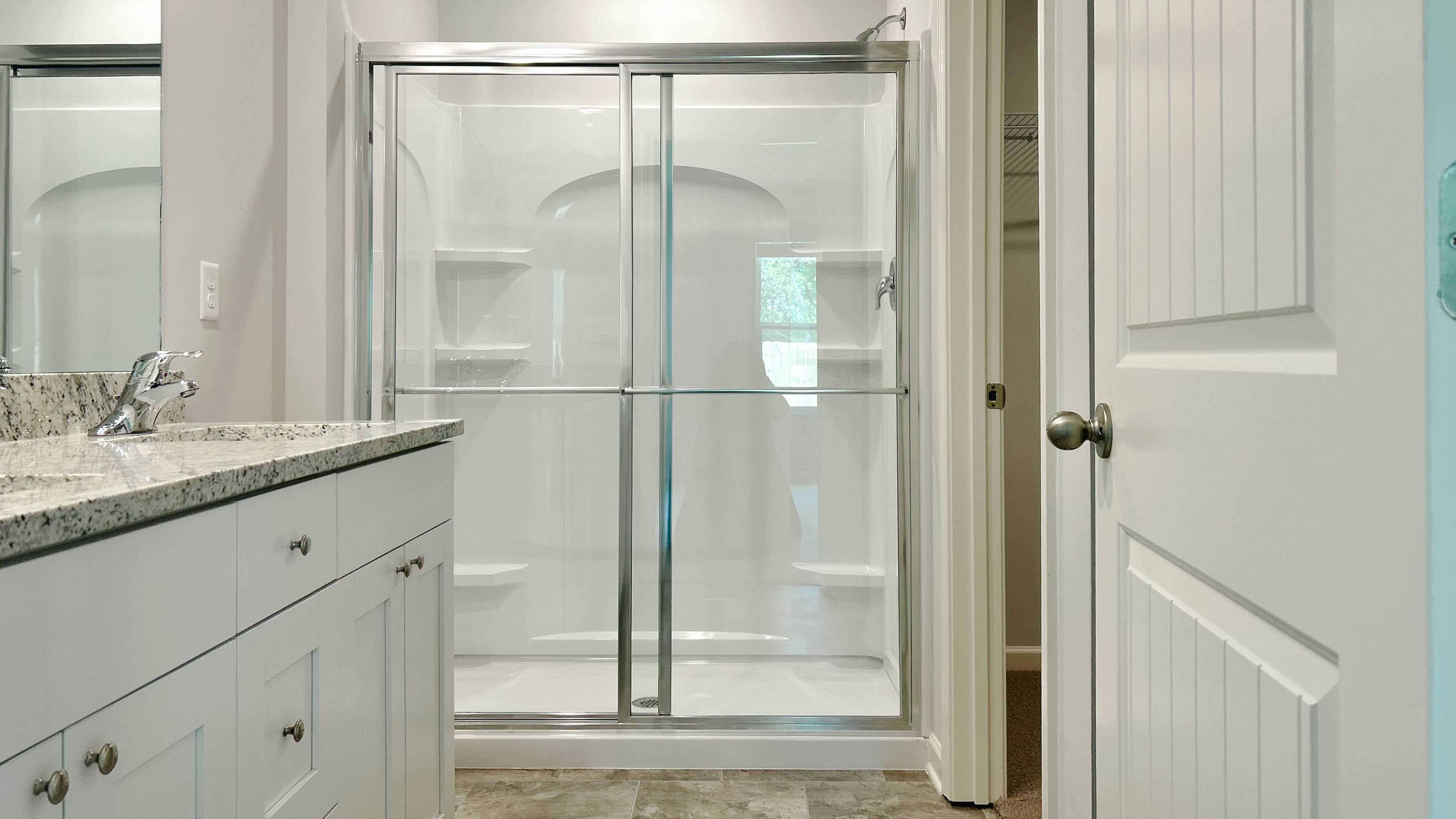 Interior bathroom with shower and white cabinets