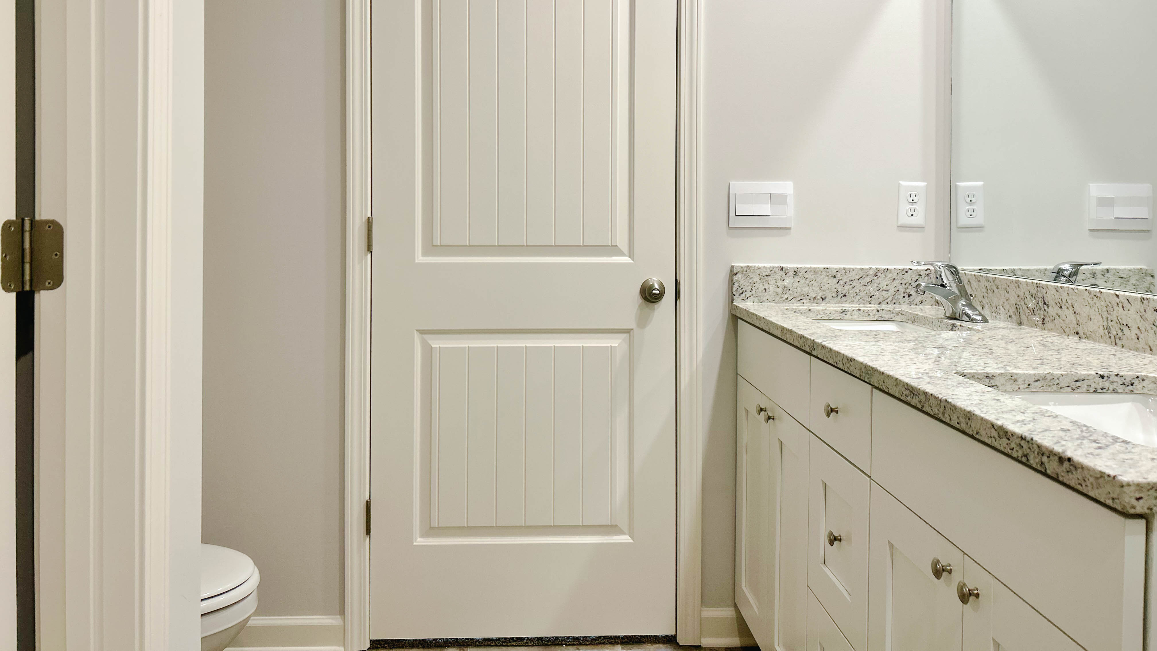 En suite primary bathroom with granite countertops