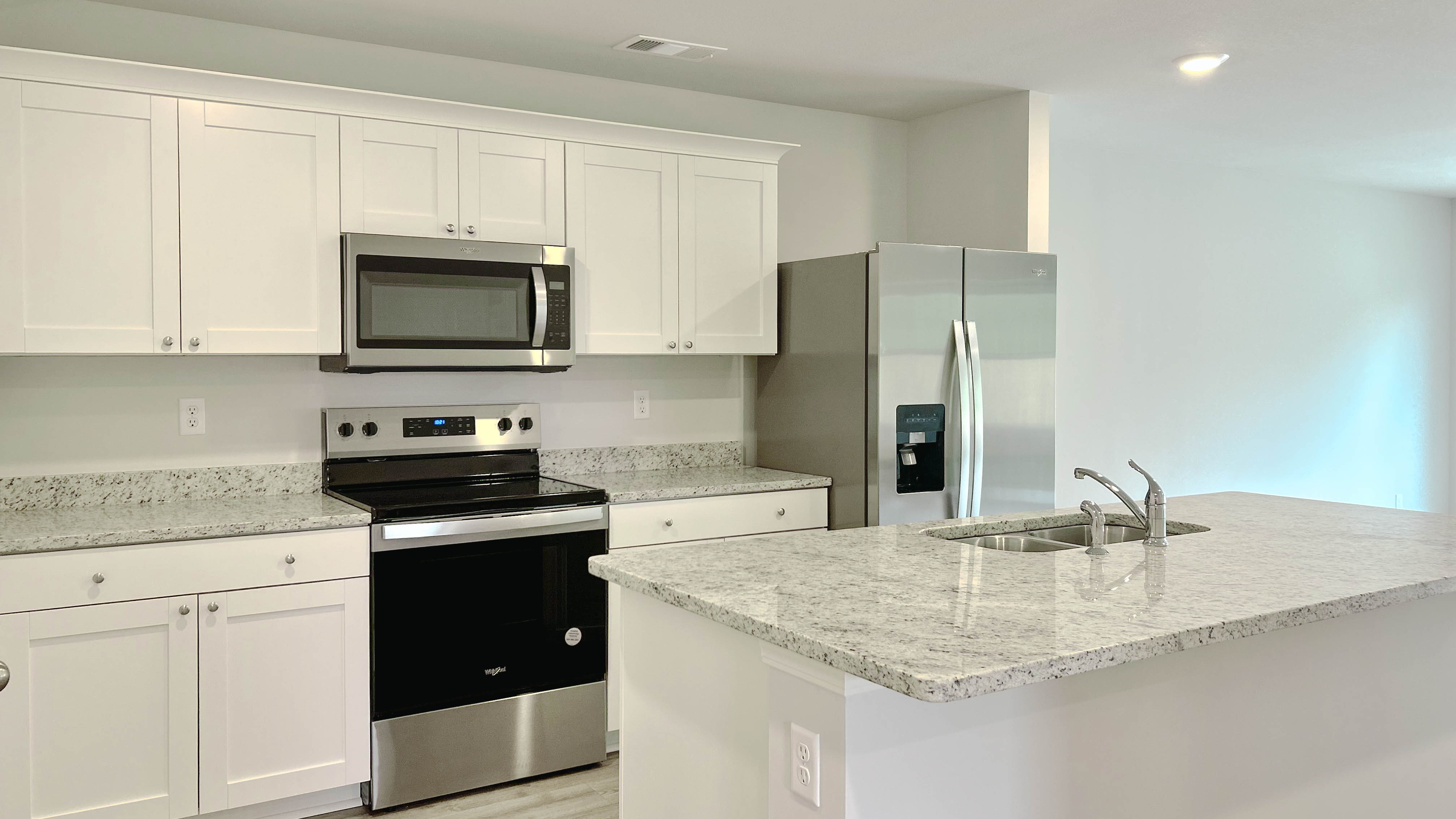 Beautiful kitchen area with light cabinets and granite countertops
