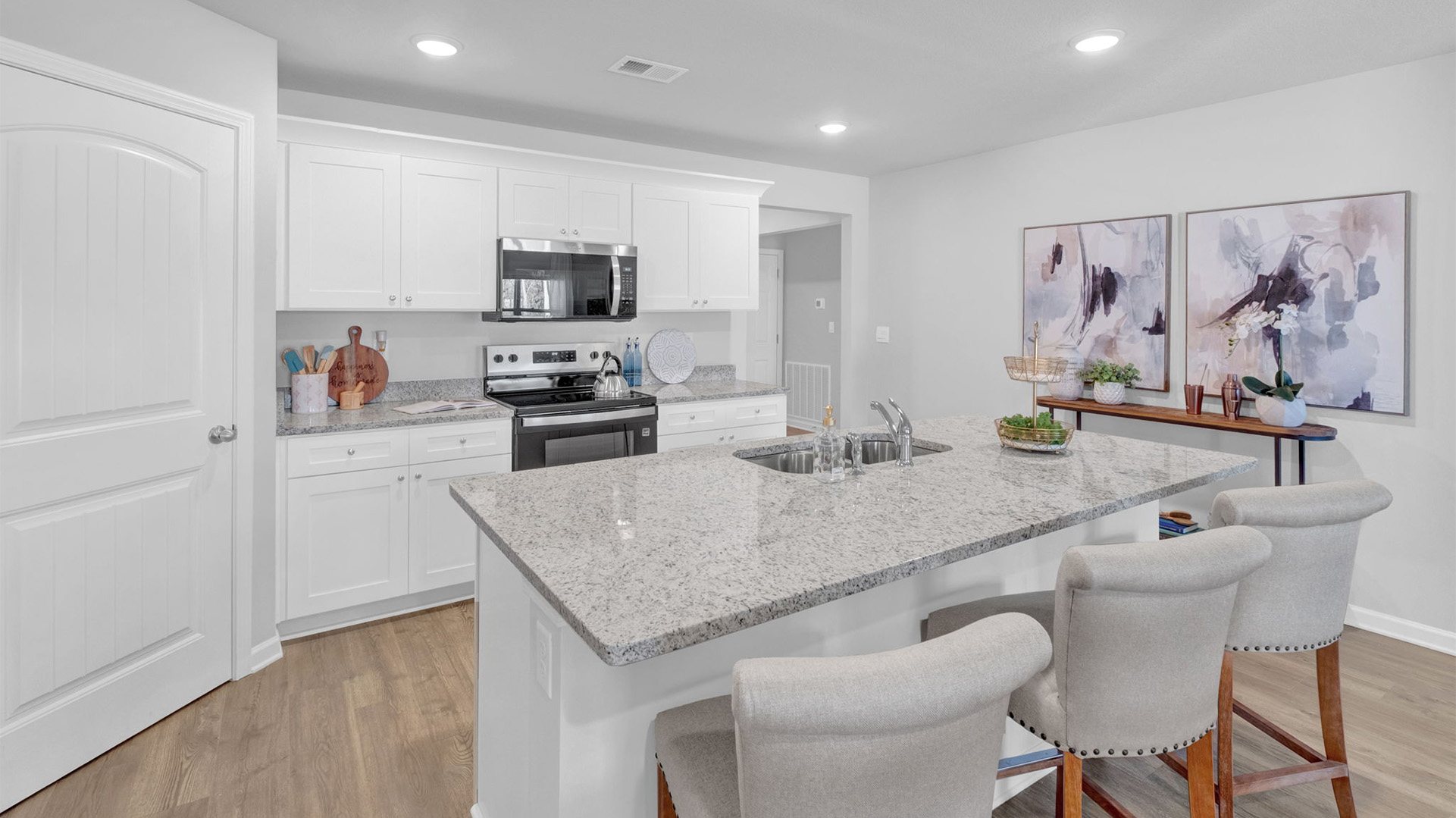 Kitchen area with light cabinets and stainless steel appliances