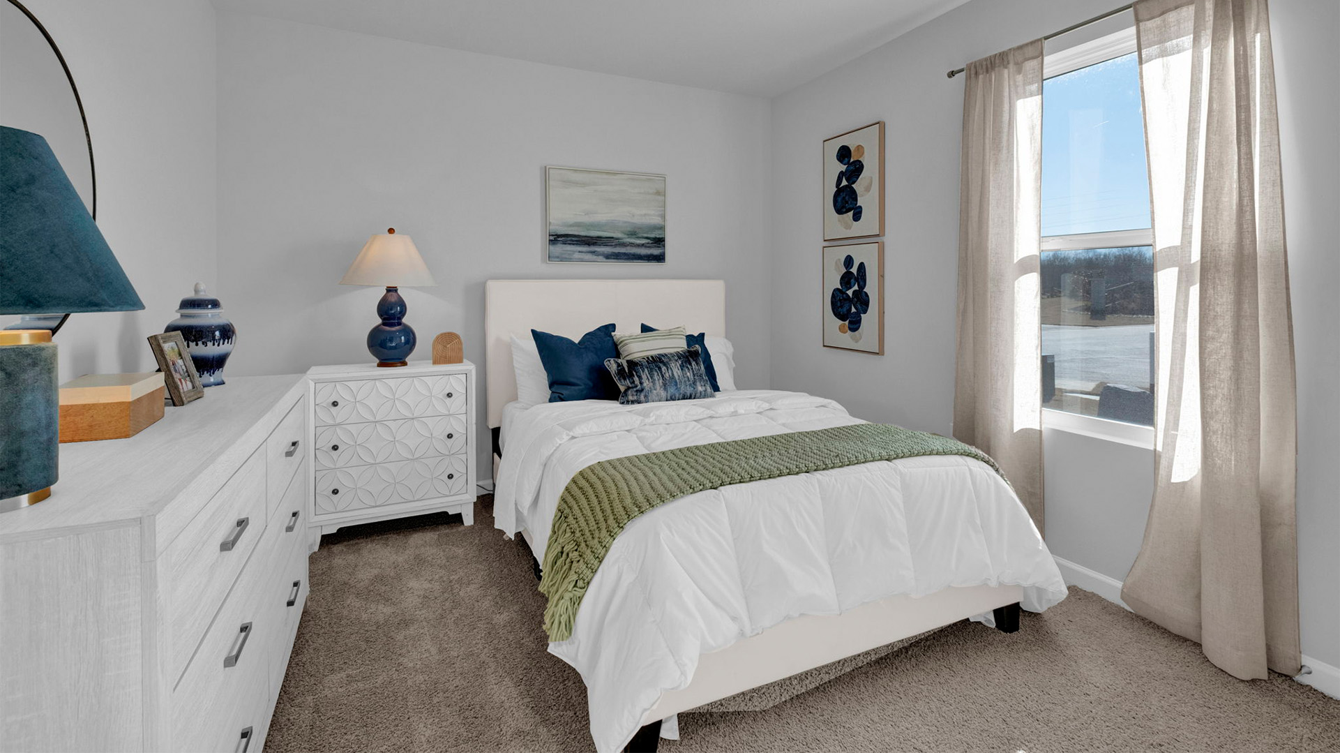 Bedroom two with a large window overlooking the front yard