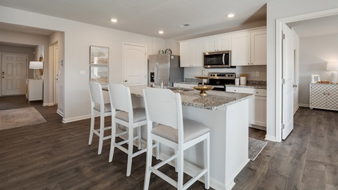 Kitchen area opens up at the end of long entry hall